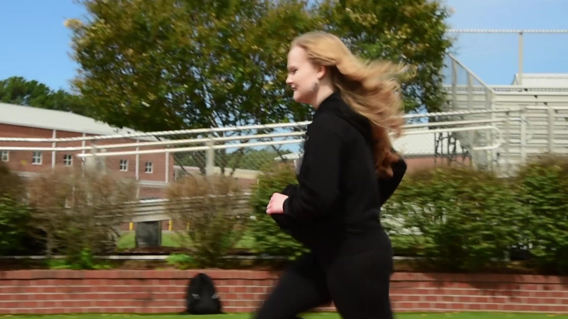 A student runs past the school in Raider Promo